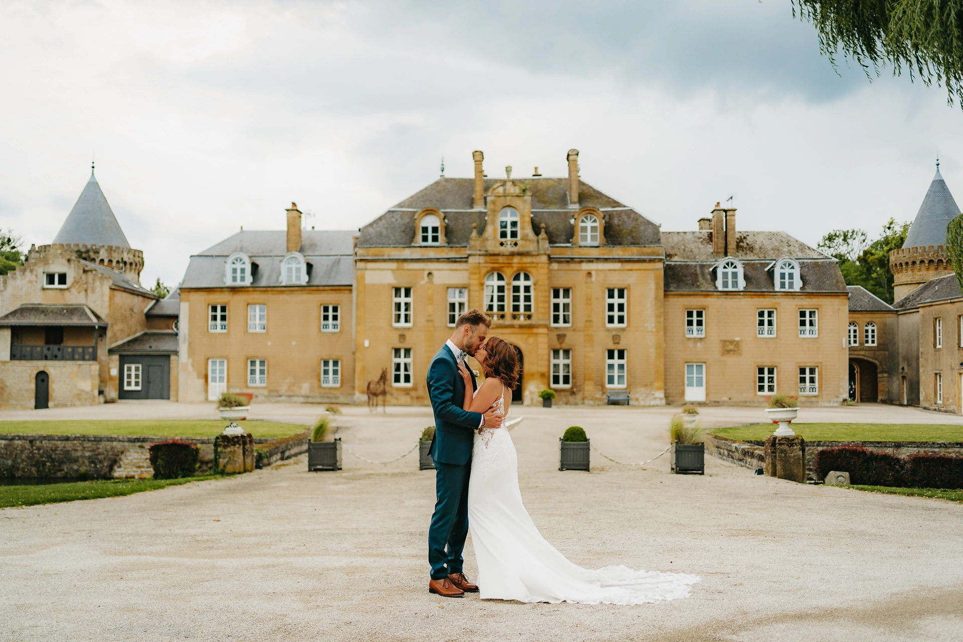 Couple enlacé devant un château, photo lumineuse et intemporelle